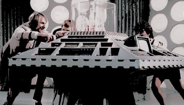 a photo of the fifth doctor, tegan, and turlough, all balanced against the tardis console.